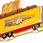 ピンバッジ・マクドナルドＭコカコーラ金色壜の絵のトラック車