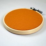 ピンバッジの壁掛け・オレンジ色フェルト刺繍フープ直径10CM