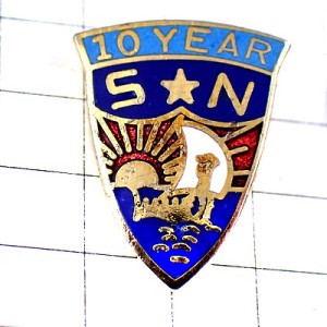 ピンバッジ・太陽と白い帆船アルファベットＳＮ紋章10年